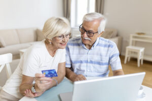 elderly couple paying bills online